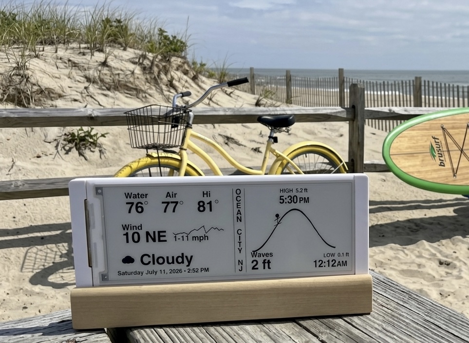 Wave Clock on its handcrafted wooden stand, sitting on a dune fence overlooking the beach in Ocean City, NJ